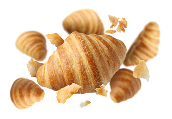 Delicious croissants and crumbs in air on white background. Puff pastry