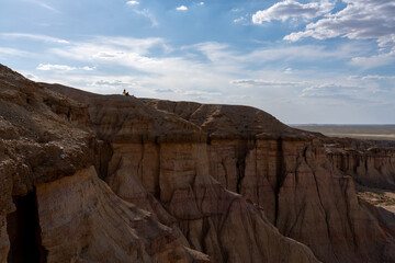 Fototapeta premium Solo Traveler Sitting on Mongolian Desert Cliff