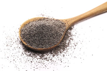 Ground poppy seeds pile in wooden spoon isolated on white background, macro 