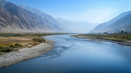 Obraz premium Serene River Flowing Through Majestic Mountain Landscape in Daylight