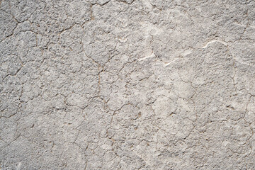 Cracked concrete wall covered with gray cement surface. Grey old wall with shabby damaged plaster or cement and brick background of an vintage dirty exfoliating plaster. Mock up.