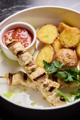 Delicious Grilled Chicken Skewers Served with Potatoes and Flavorful Sauce for Enjoyment