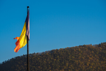 Brasov, Romania - October 22, 2024: The Romanian Flag Against a Clear Blue Sky: A Vibrant Symbol of National Pride and Cultural Heritage.