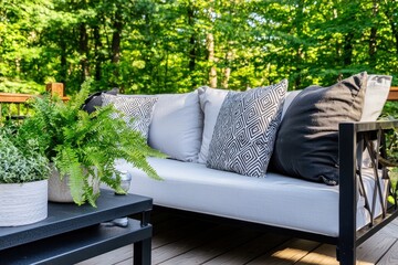 Serene Outdoor Living Space with Comfortable Sofa Pillows and Lush Greenery Amidst a Verdant Forest Backdrop