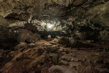 a tourist walks in the Ancient underground cave gruta de san pedro in atocha bolivia with beautiful stone shapes, stalactites and groundwater landscape
