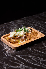 A Mouthwateringly Delicious Gourmet Dish Impeccably Served on a Rustic Wooden Plate