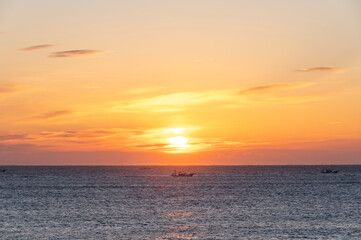オレンジ色に朝焼けする空と海