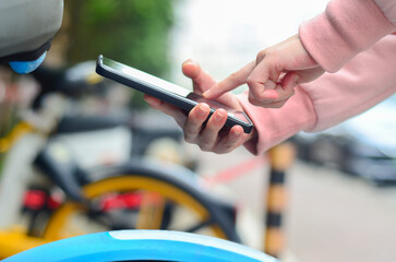 People use smart phone to scan the QR code on a shared bike to unlock it.