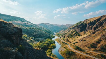 Scenic River Flowing Through Lush Green Valley Under Blue Sky