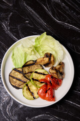 Delicious Grilled Vegetables Salad Served with a Variety of Fresh Greens on a Vibrant Plate