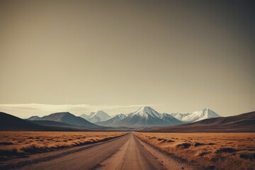 Fototapeta premium dirt road in the middle of a desert with mountains in the distance