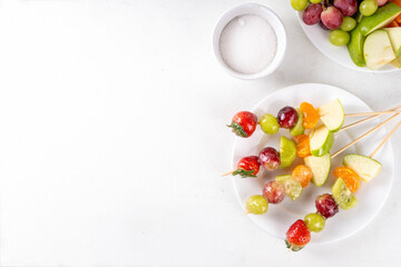 Traditional Chinese sweet street food recipe Tanghulu, fruit skewer on stick with crunchy sugar glaze, easy healthy dessert. Step by step preparation of Tanghulu with ingredients on table, top view