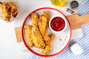 Tasty flavorful freshly cooked chicken nuggets or strips, with golden corn breading, fried in less oil. Homemade balanced diet fast food alternative