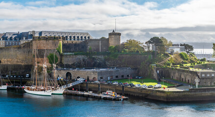 Obraz premium A view from the Garden of Explorers towards boats moored by the castle at Brest, France on a sunny day in autumn