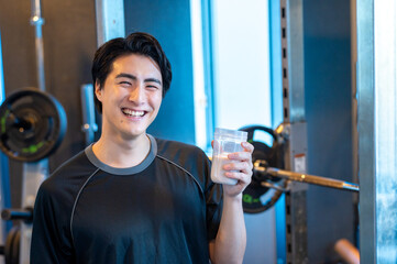 ジムでプロテインを飲む日本人男性
