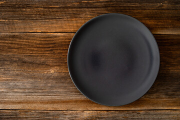 Empty black plate on wooden rustic table	