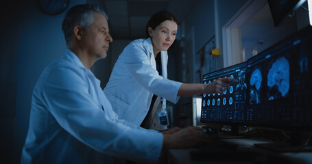 In Control Room Doctor and Radiologist Discuss Diagnosis while Watching Procedure and Monitors...