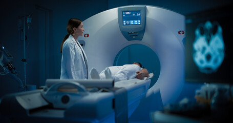 In Medical Laboratory Radiologist Controls MRI or CT or PET Scan with Female Patient Undergoing...