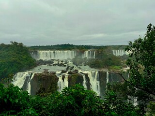 Iguazu Falls. Water falling on multiple levels surrounded by dense jungle. Natural panoramic view