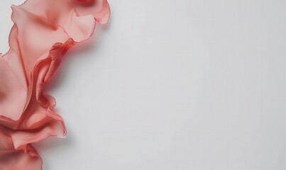 Delicate pink fabric gently flows on a white surface, ideal for background textures or product presentation
