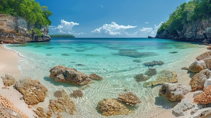 Fototapeta premium A serene beach scene with clear turquoise water and rocky formations under a bright sky.