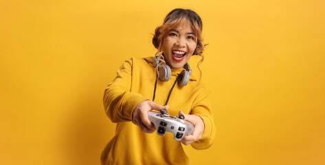 Excited asian woman with headphones holding a joystick for video games © Ljupco Smokovski