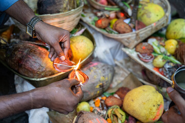 Indian man lighting diya for chhath puja celebration
