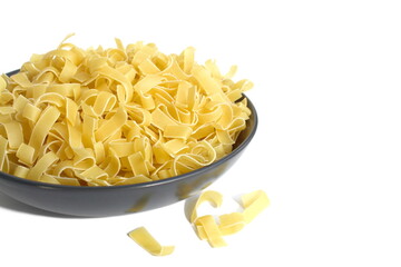 There is a black plate with dry pasta on a white background.	