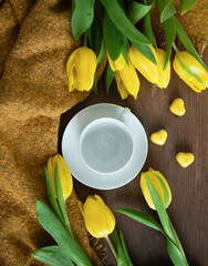 An empty cup with yellow tulips