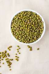 Mung beans in a bowl on a light background, top view
