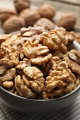 Fresh walnuts in bowl on table, closeup