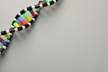 Colorful DNA structure model on light grey background, top view. Space for text