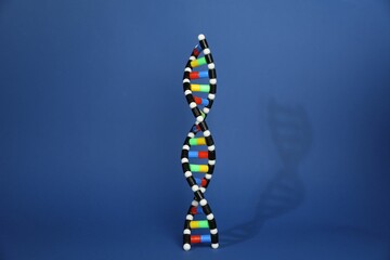 Colorful DNA structure model on blue background