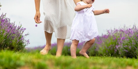 Naklejka premium Mother and child's legs running on grass