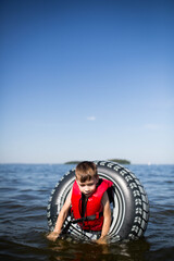 Młody chłopiec bezpiecznie żegluje z rodzicami w kamizelce ratunkowej © Katarzyna Krociel