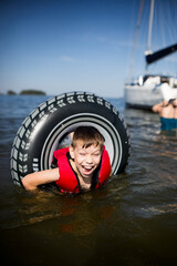 Młody chłopiec bezpiecznie żegluje z rodzicami w kamizelce ratunkowej © Katarzyna Krociel