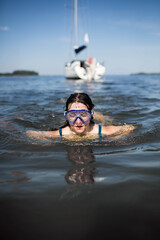 Nastolatka, szczupła dziewczyna skacze do wody z pokładu łodzi, śmieje się i świetnie bawi. © Katarzyna Krociel