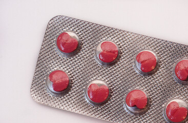 Red medicine pills in a blister pack isolated on white background, healthcare and medicine concept.