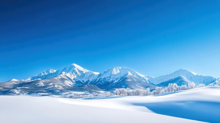 A stunning winter landscape featuring majestic snow-covered mountains under a clear blue sky. The serene scene captures the beauty of nature and winter's tranquility.