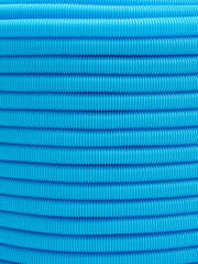 Plastic corrugated hose close-up. Blue background, texture.