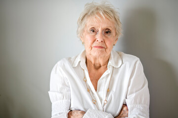 Beautiful angry senior woman in front of a white background