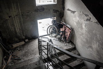 Abandoned wheelchair in ruined building staircase