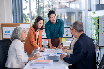 A group of people are gathered around a table with a whiteboard