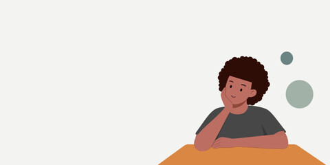 A man is sitting at the table. The expression on his face was like he was thinking. He had curly brown hair.