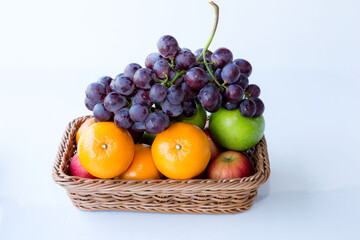 Assorted fresh mix fruits in a rectangle basket on white background, concept fruit in shop and supermarket..
