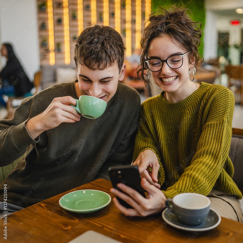 Wall mural couple explore internet on mobile phone while drink coffee at cafe