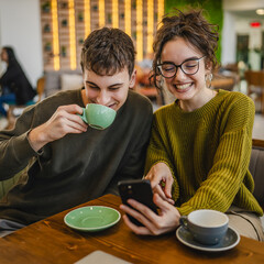 couple explore internet on mobile phone while drink coffee at cafe