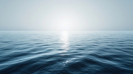 Obraz premium Blue ocean under a clear sky with bright sun shining over the water and gentle waves lapping at the shore