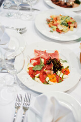 Elegant Table Setting With Delicious Italian Caprese Salad and Fresh Ingredients..