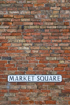 Vintage Market Square sign positioned on an old red brick wall in an English village in Warwickshire. Vertical format